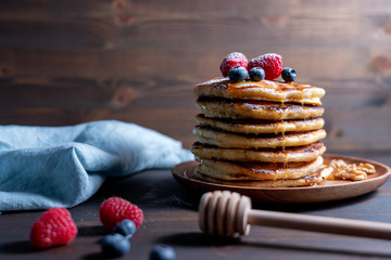 Closeup shot of American pancake stack with rustic wooden backdrop and copy space for text. . Maple...