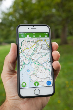 BATH, UK - SEPTEMBER 1, 2015 : Close-up of a male hand holding up a smartphone displaying an Ordnance Survey map in the ViewRanger application.