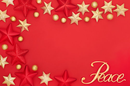 Christmas gold peace sign with star and bauble decorations on red background forming an abstract border with copy space. Traditional greetings card for the festive season.