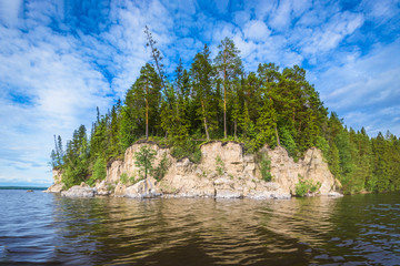 Panoramic view of the rocky cliff near the river Kama, blue sky with white clouds.