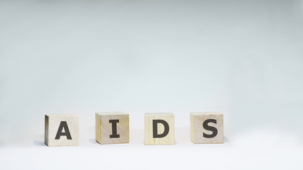 Word AIDS with wooden letters on white background.