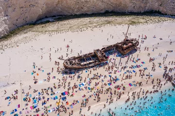 Crédence de cuisine en verre imprimé Plage de Navagio, Zakynthos, Grèce Tourists enjoy summer time by abandoned rusty ship on shipwreck navagio beach