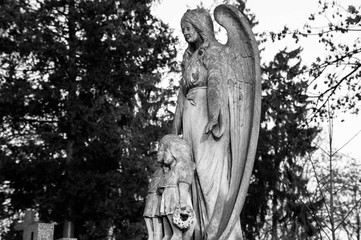 Old photo of the angel monument with children. Black and white photo.