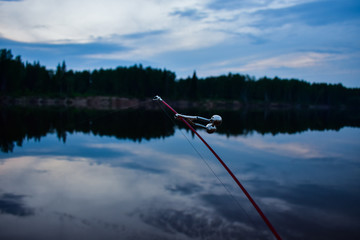 A fishing rod with a bell on the river in the evening in the summer. Fishing.