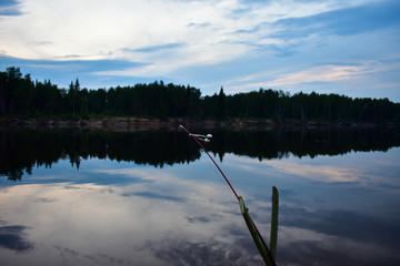 A fishing rod with a bell on the river in the evening in the summer. Fishing.