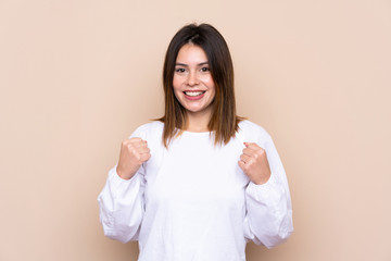 Young woman over isolated background celebrating a victory