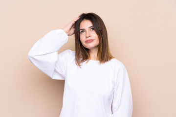 Obraz premium Young woman over isolated background having doubts and with confuse face expression