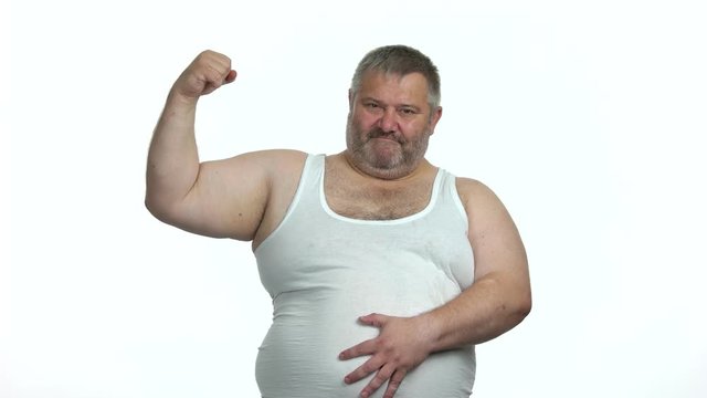 Fat man with big belly showing biceps. Overweight middle-aged man posing on white background. Space for text.