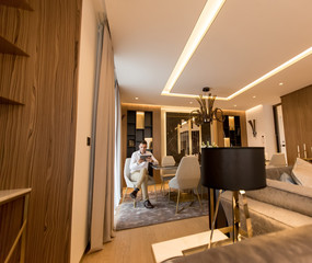 Handsome young man using digital tablet at luxury apartment