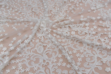 Texture lace fabric. lace on white background studio. thin fabric made of yarn or thread. a background image of ivory-colored lace cloth. White lace on beige background.