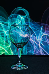 Wine glass on a background of colored smoke