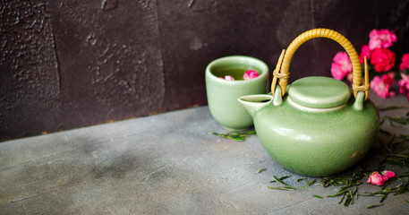 Chinese green tea with roses on dark background