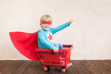 Happy superhero child playing at home