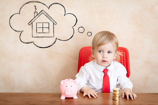Happy Child With Coins And Piggy Bank. Funny Kid Playing At Home. Real Estate, Investment And New Home Concept