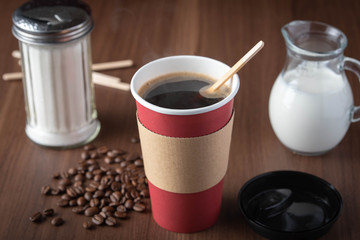 coffee in disposable paper cup with beans