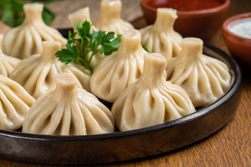Georgian dumplings Khinkali with meat and red papper, on brown plate