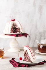 Pancho cake with cherry filling in the cut on the plate closeup on a light background with copyspace.