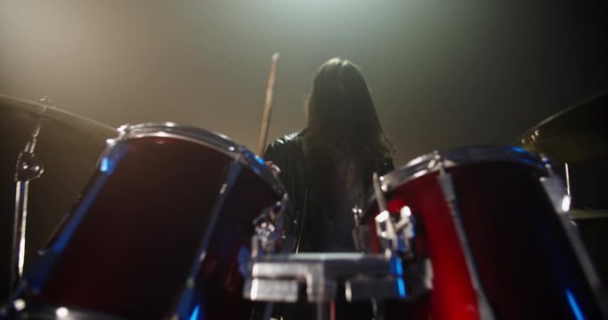 A professional drummer is playing rock music with band. Experienced musician is beginning the performance in club - music concept 4k footage