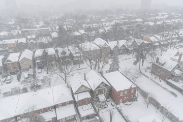 Residential houses and roofs covered with snow in winter snowstorm in Toronto