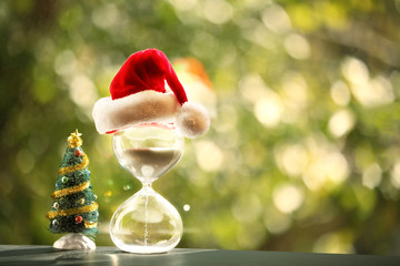 Christmas countdown. Modern Hourglass and Christmas tree -- sand trickling through the bulbs of a crystal sand glass. Holiday-themed image.