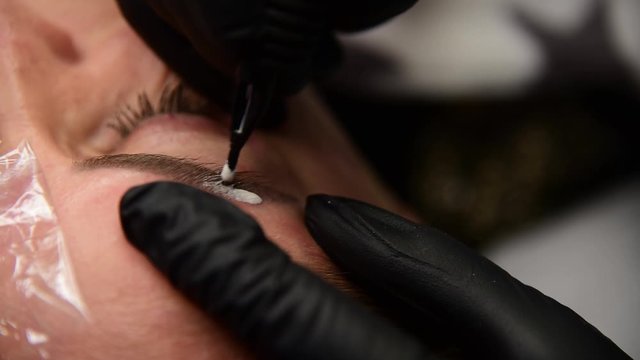 Woman in process of eyebrow tattoo removal. Beautician tattoo salon.