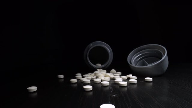 Macro shot of tablets or pills on a table zooming into the bottle.