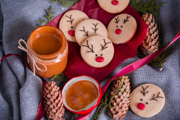 Christmas cookies with homemade salted caramel on a wooden background, neon lights, cinnamon sticks.