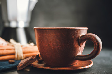 Brown cup with hot drink, coffee, tea or chocolate on dark background