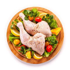 Raw chicken thighs and vegetables on white background 