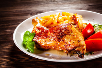 Roast chicken leg with french fries and vegetable salad 