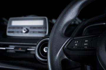 Fototapeta na wymiar Multimedia button on multifunction steering wheel in a luxury car.