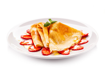 Tasty crepes with strawberries on white background