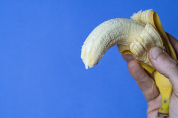 banana in hand with blue background