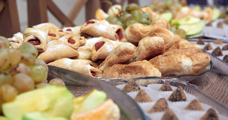 cookies and buns in a glass plate on a wooden table. candies