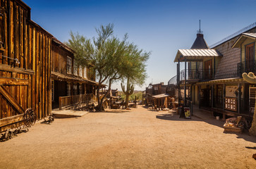 Old Western Goldfield Ghost Town square with huge cactus and saloon, photo taken during the sunny day with clear blue sky - obrazy, fototapety, plakaty