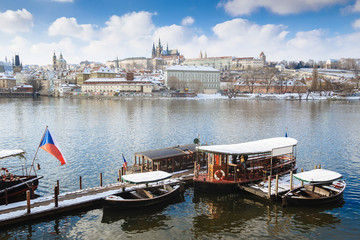 Fototapeta na wymiar Panorama on Prague Castle and river Vltava with local ferry serving as public transport, taken during winter