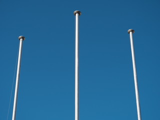 Fototapeta na wymiar Tokyo,Japan-November 29, 2019: Three flagpoles under blue sky in Tokyo