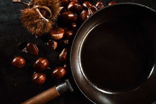 Maronen mit der Esskastanien Frucht und einer grusseisernen Pfanne