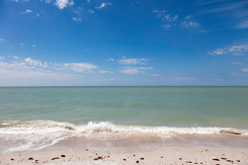 Fototapeta na wymiar Coast of Sanibel Island, sand, water, waves, blue sky, Florida