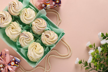 Homemade zephyr or marshmallows in a box on a pink background, horizontal orientation