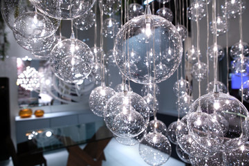 lighting balls on the chandelier in the lamplight, lightbulbs hanging from the ceiling in the cafe, selective focus, horizontal