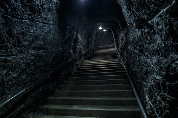Fototapeta na wymiar Empty lonely abandoned stairs in a rocky underground, stairway to heaven or hell