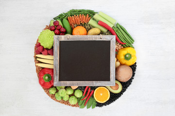 Vegan food for a healthy diet concept with foods high in protein, vitamins, minerals, anthocyanins, antioxidants, smart carbs & dietary fibre. Flat lay on rustic wood with a blackboard & copy space.