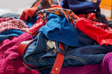 Dump of used clothes. Pile of scattered second-hand clothes on a white background