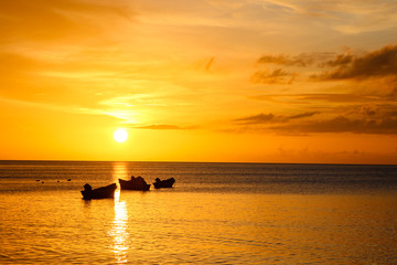 Fototapeta premium sunset on sea with fisherman boats