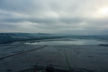 Beautiful aerial panoramic of Waverley Lakes, Rotherham, during a misty morning sunrise over the cold body of water. Winter, South Yorkshire, UK
