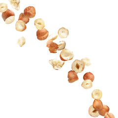 Falling hazelnuts on white background