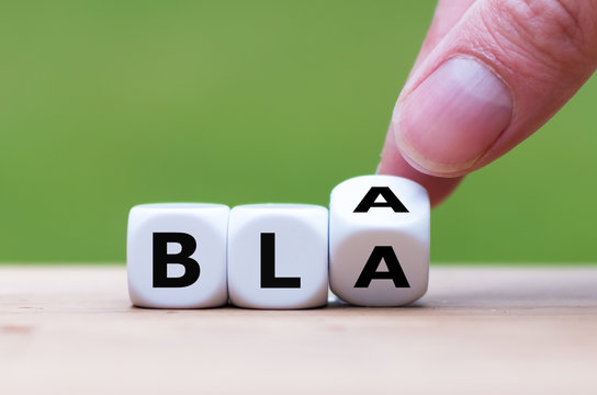 Hand turns a dice and changes the word "bla" to "bla".