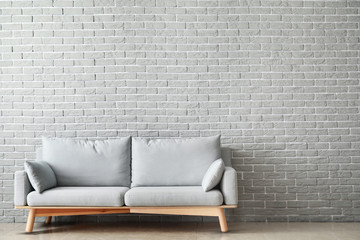 Soft couch near brick wall