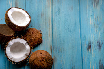 Coconut chopped half on a wooden background of blue tseta. Tropical background with place for copy space. View from above